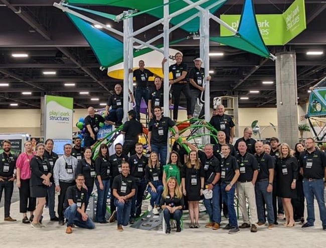 Play & Park employees posing for photo in front of playground equipment indoors