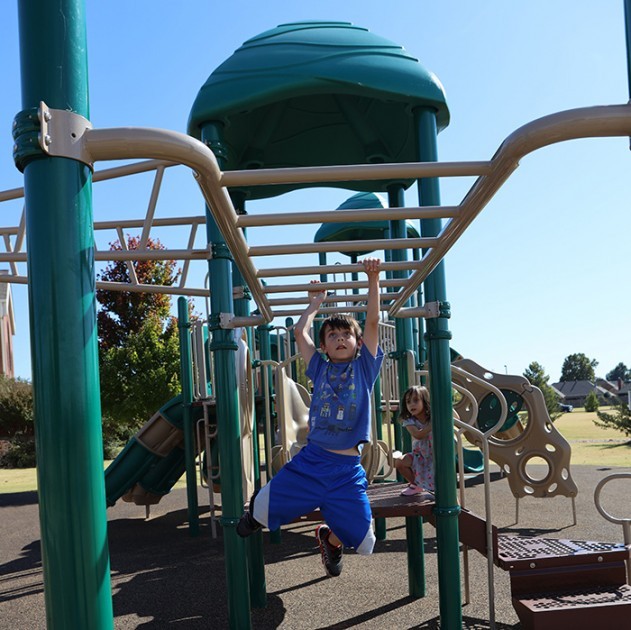 st-monica-boy-swinging-from-monkeybars