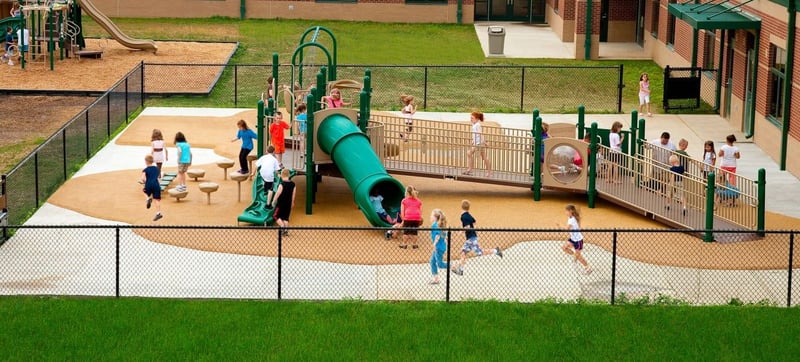 aerial shot of children playing on a large green colored park