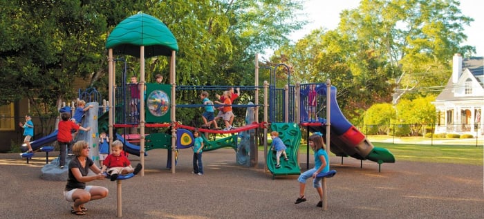 small children playing at a colorful park in front of a park