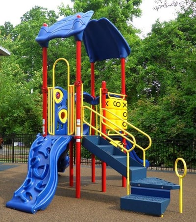 yellow blue and red park structure with a small rock climbing slide