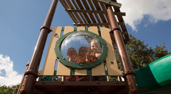 children smiling behind glass bulb at park