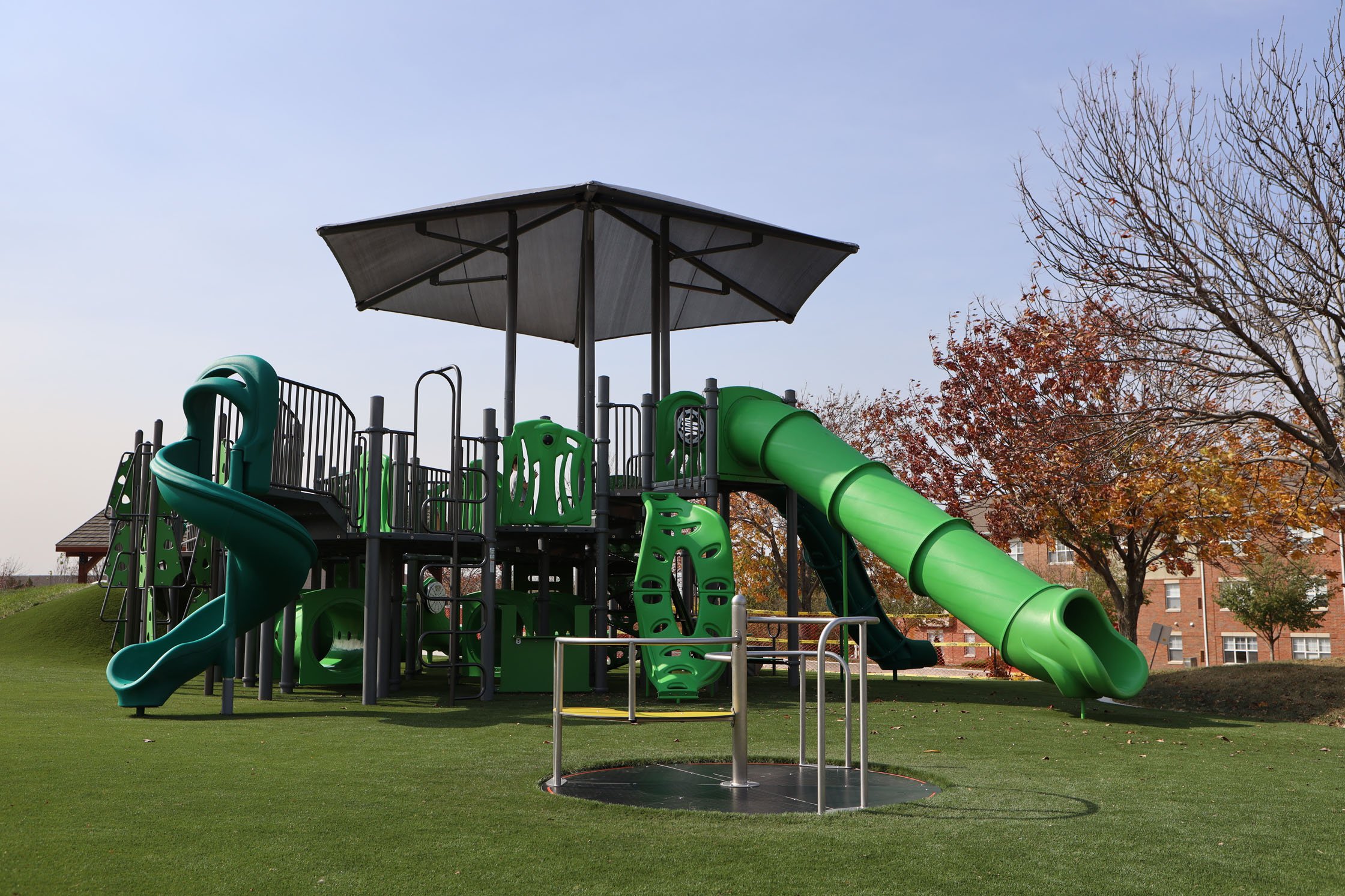 Green playground park with green slides and grey cover