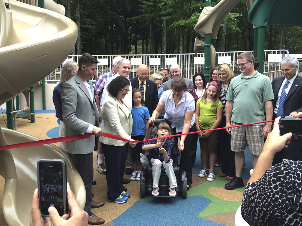 Group of individuals cutting a rope opening at playground 