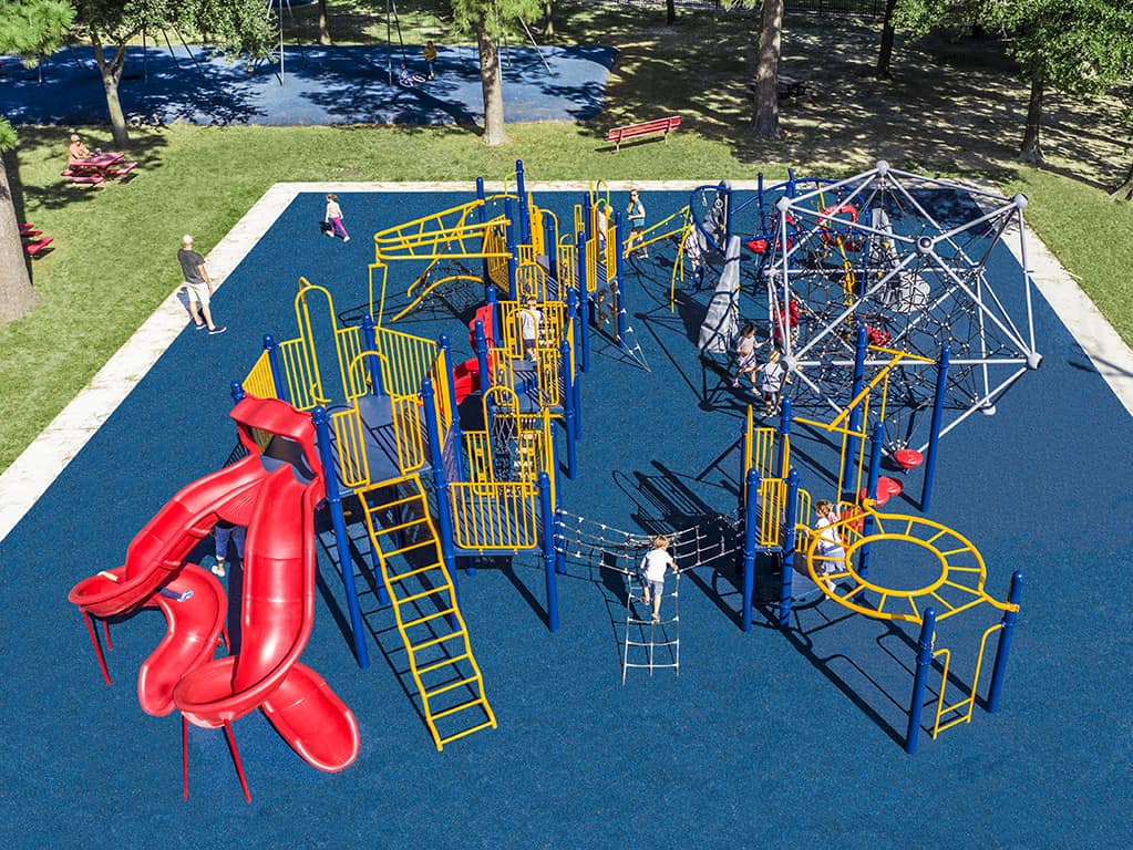 aerial shot of a park with yellow bars a red slide and blue turf