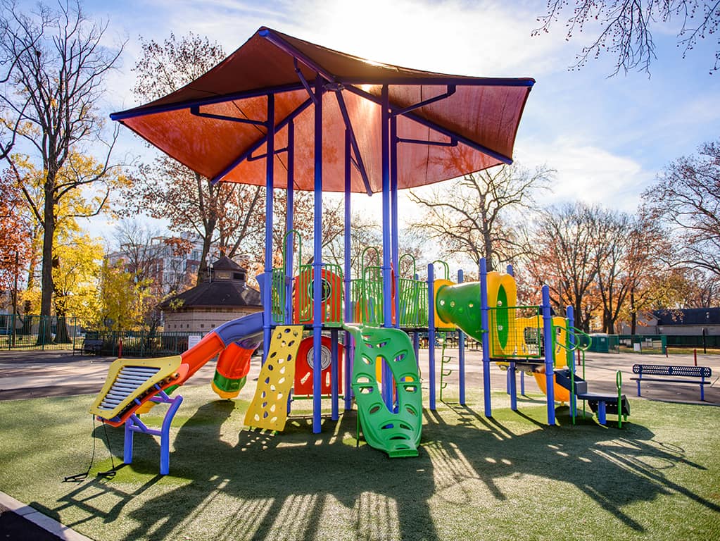 colorful playground during the fall with a maroon cover on the top