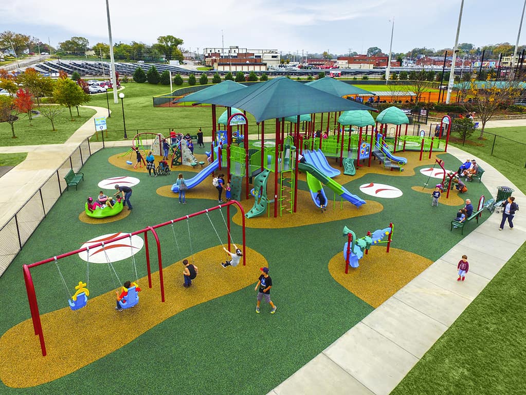 aerial shot of a green colored park with children playing on it