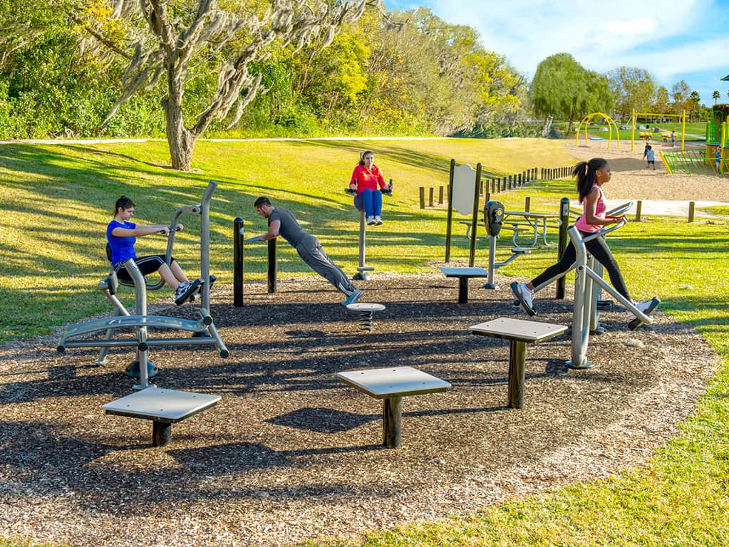 shot of people working out on fitness equipment outside at park