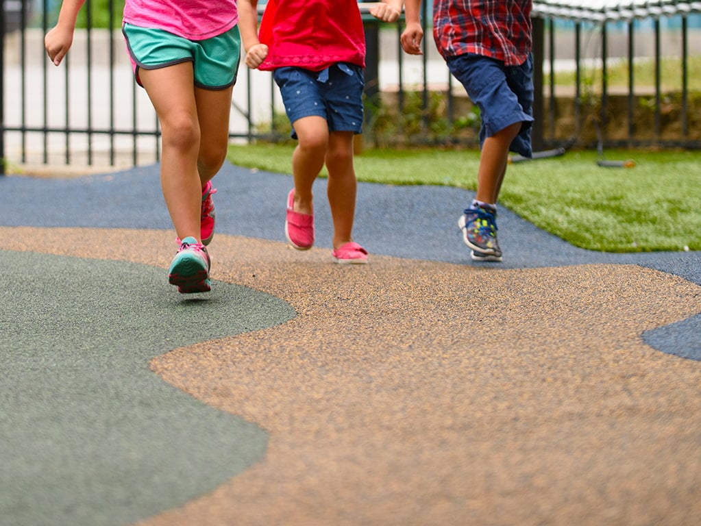 shot of young children's legs as they run at a playground