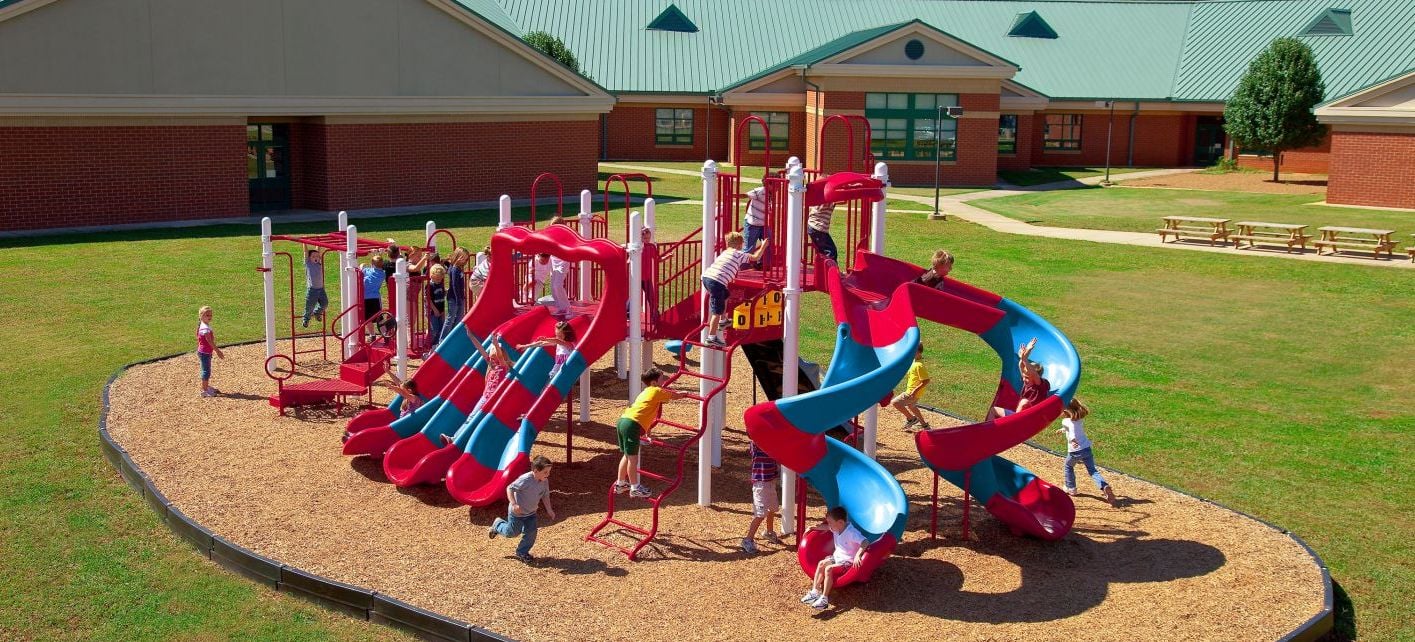blue and red colored park with children climbing up the rails