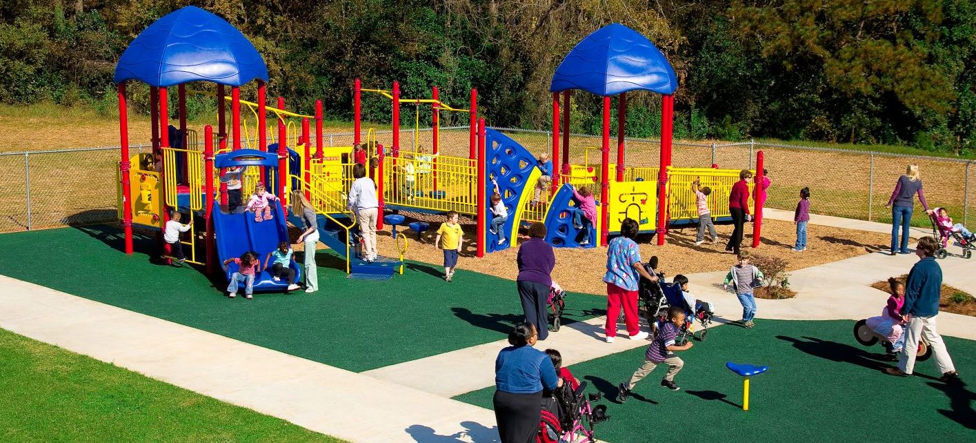 small children playing at park red yellow and blue colored with their moms 