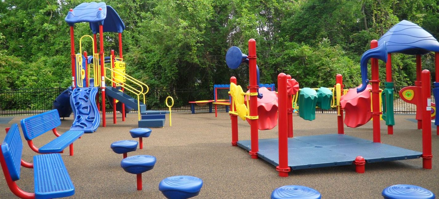 yellow blue and red park structure with a small rock climbing slide