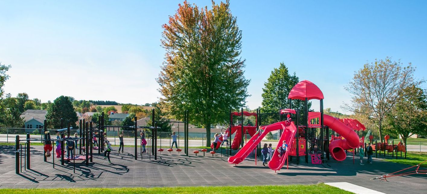 image of red colored park with children playing on swing  during the fall