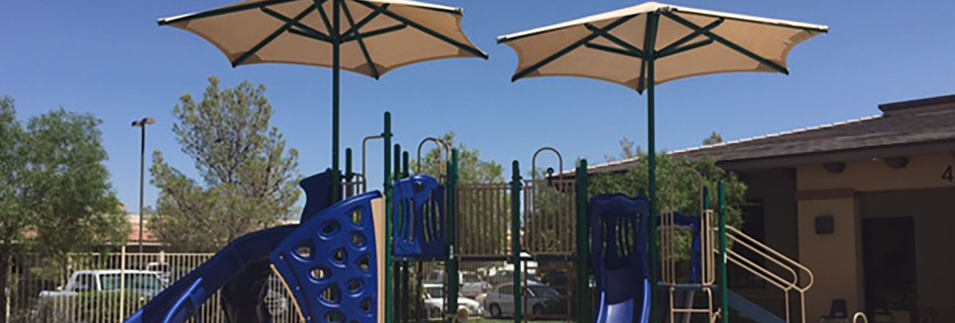 image of a blue themed park with tan overhead structures during the summer