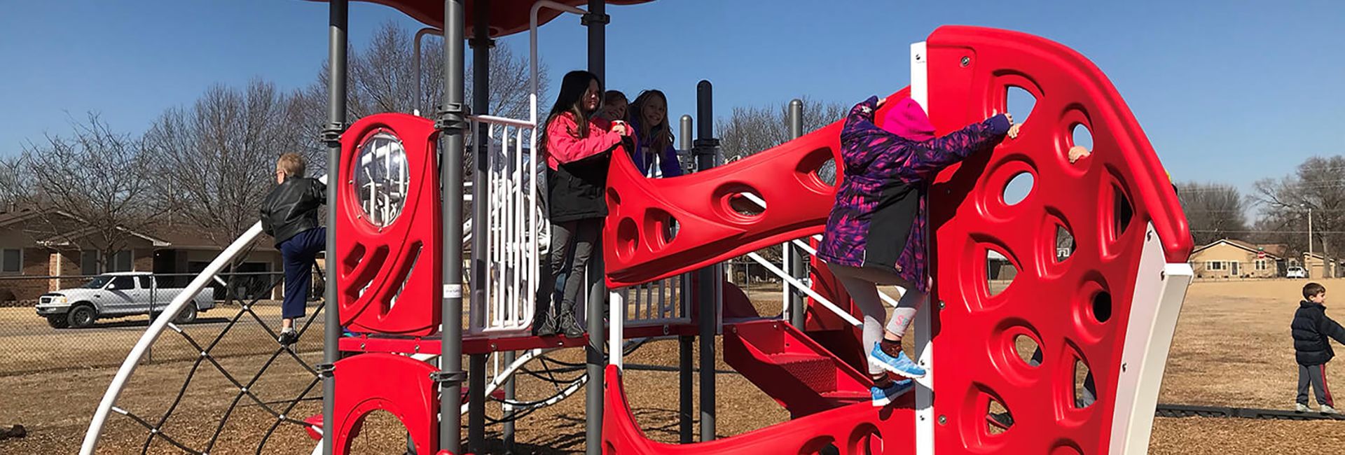 Children playing on red colored bar with holes at playground