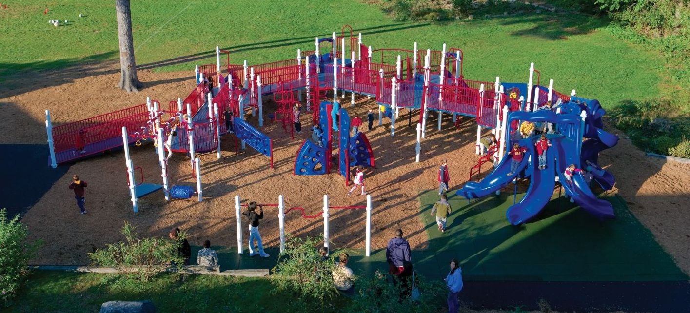 aerial shot of children playing on a large red and blue colored park