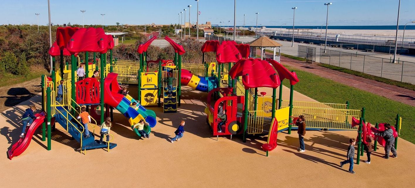 aerial shot of red and yellow colored park brown turn and children playing on it