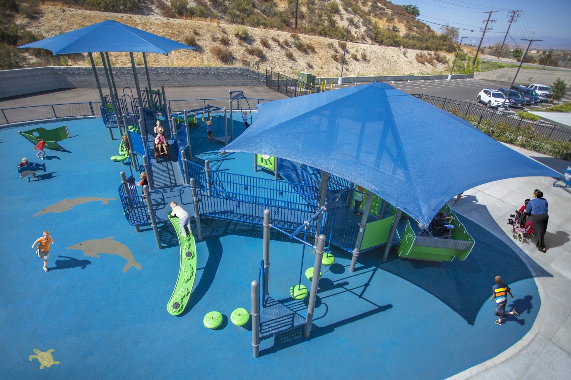 Featured image of aerial view of blue colored park on blue turf with children playing on it