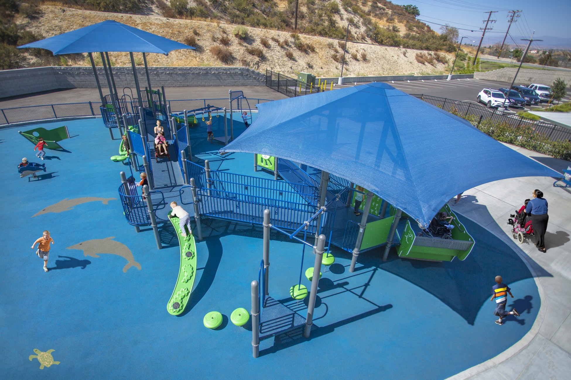 aerial view of blue colored park on blue turf with children playing on it