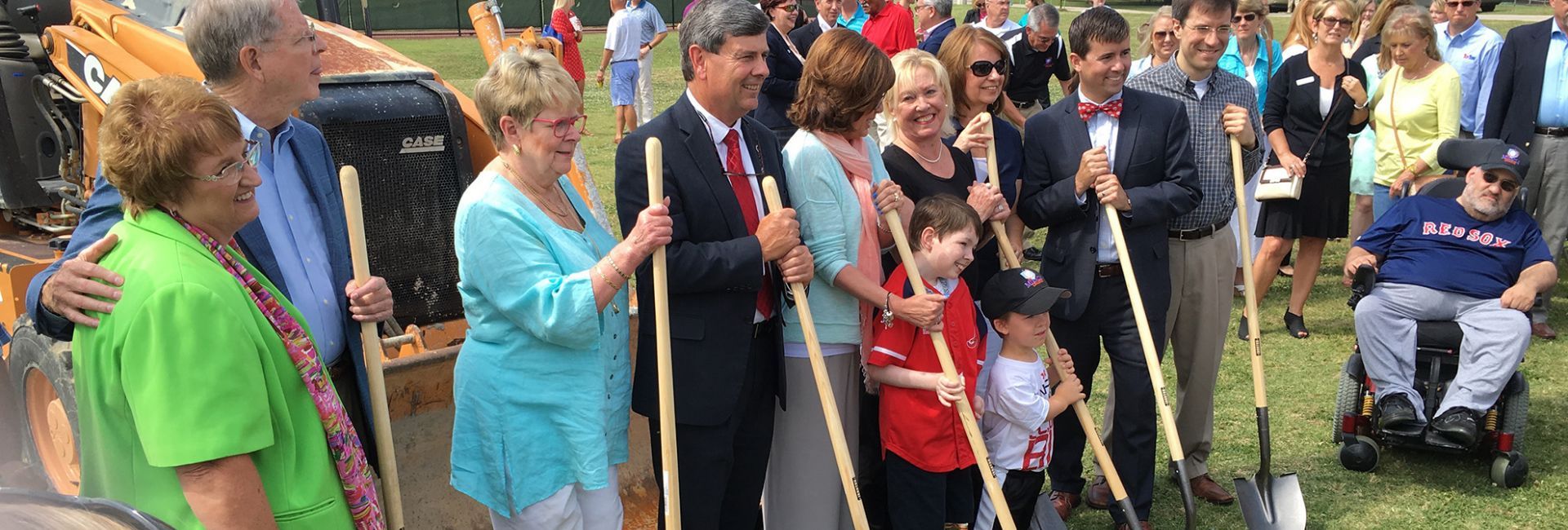 Group of people holding shovels smiling at opening of park