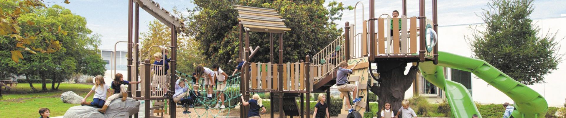 Featured image of children playing at wood themed park with large green trees in background