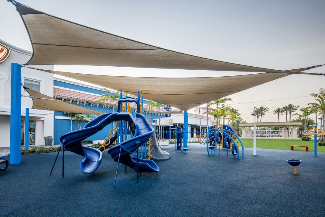 Featured image of blue Gulf Coast Mall Playground on blue turf with large overhead structure above