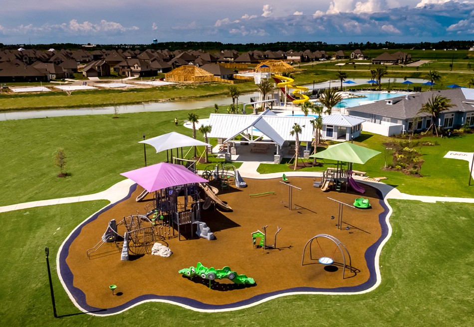 Aerial view of a park with brown flooring and pink, white, and green covers on top of the structures