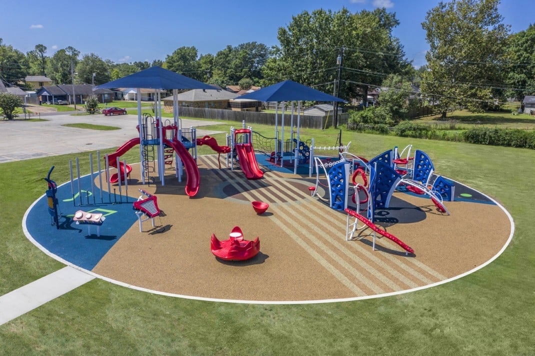 Visual and Performing Arts School with red slides, blue covers, on brown and blue turf