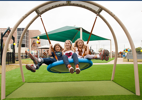 3 girls smiling swinging on blue swing at park