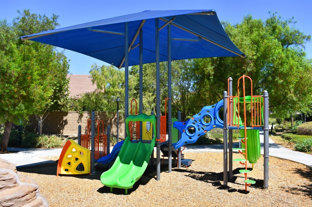 Featured image of The Lakes at Menifee Playground with blue cover above it and green slides