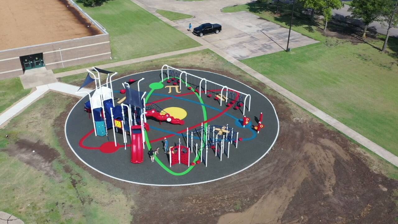 Featured image of aerial view of blue and red colored park on gray turf with colorful science illustration in middle