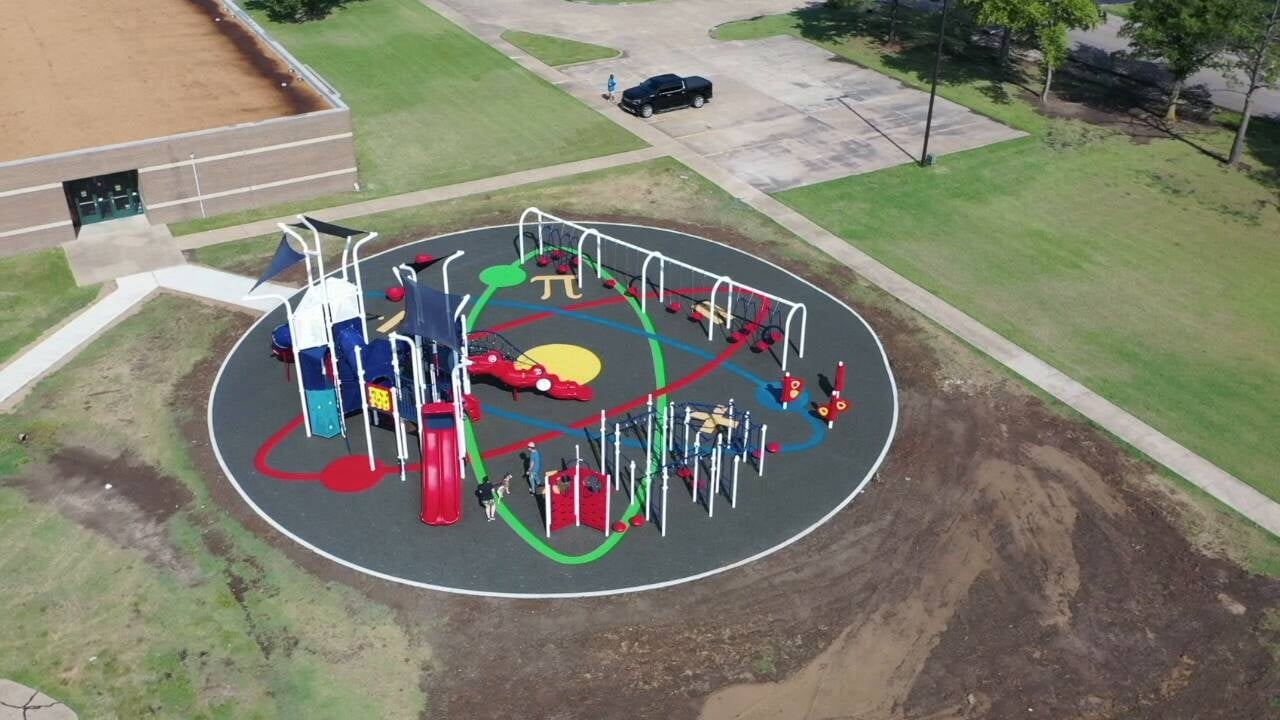 aerial view of blue and red colored park on gray turf with colorful science illustration in middle